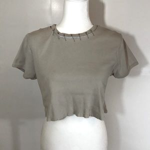 Distressed crop top featuring safety pin neckline